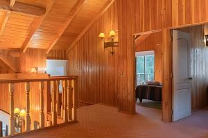 ein Flur mit Holzvertäfelung und ein Bett in einem Zimmer in der Unterkunft Impresionante casa + Starlink | Bosque y estufa in Pucón