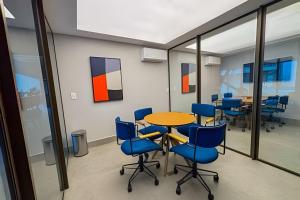 a conference room with a table and blue chairs at Beach Class Meireles by HostFacil in Fortaleza +291 photos