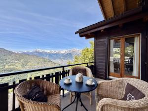 a patio with chairs and a table on a balcony at Eanta SUNNY & MOUNTAIN chalet 10 pers by Alpvision Résidences in Veysonnaz