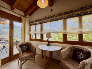 a room with two chairs and a table and windows at Eanta SUNNY & MOUNTAIN chalet 10 pers by Alpvision Résidences in Veysonnaz