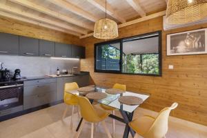 a kitchen with a table and yellow chairs in it at Le Pech Eternel-Lodge Spa Tilleuls in Sarlat-la-Canéda