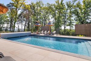 a swimming pool with two loungers next to a fence at Le Pech Eternel - La Truffière in Sarlat-la-Canéda