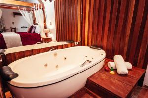 a bathroom with a large tub in a room at Chalés Recanto da cachoeira in Monte Verde +81 photos