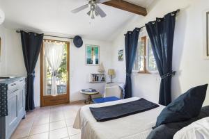 a bedroom with a bed with blue curtains and a window at Gite Insolite Mas Boutet in Argelès-sur-Mer