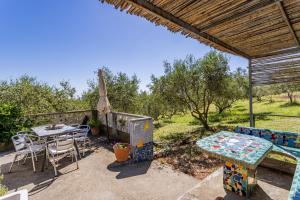 a patio with a table and chairs and an umbrella at Gite Insolite Mas Boutet in Argelès-sur-Mer