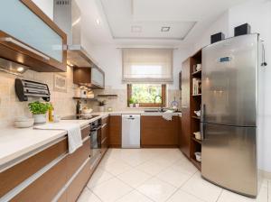 a large kitchen with a stainless steel refrigerator at Willa pod Warszawą Perfekcyjna na Eventy i Spotkania Firmowe in Kobyłka