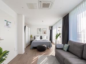 a living room with a bed and a couch at Limehome Köln Friesenplatz - Digital Access in Cologne