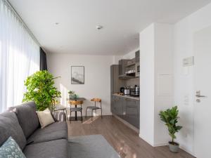 a living room with a couch and a kitchen at Limehome Köln Friesenplatz - Digital Access in Cologne