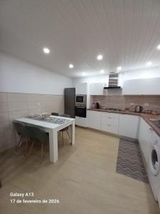 a large kitchen with a table and a stove at Apartamento do Chico in Terra Chã