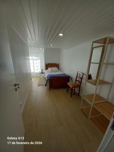 a bedroom with a bed and a chair in a room at Apartamento do Chico in Terra Chã
