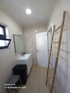 a bathroom with a white sink and a ladder at Apartamento do Chico in Terra Chã
