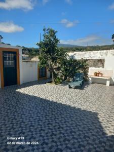 a patio with a bench and a tree on a building at Apartamento do Chico in Terra Chã