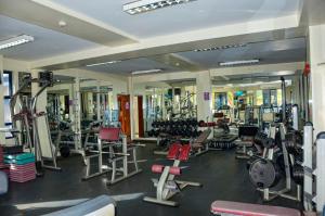 a gym with lots of exercise equipment and mirrors at Legacy Homes in Nairobi