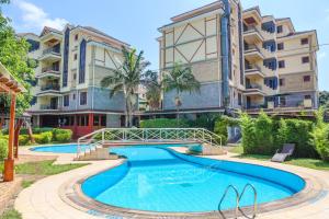 an apartment with a swimming pool in front of a building at Legacy Homes in Nairobi