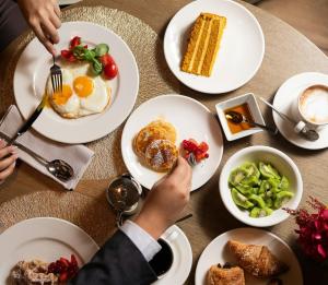 a table with plates of breakfast food on it at Rosa Grand Milano - Starhotels Collezione in Milan