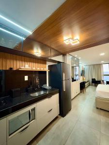 a kitchen with a refrigerator and a sink in it at Unity Cabo Branco in Penha
