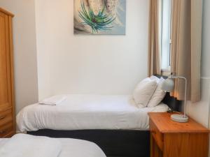 a hotel room with two beds and a lamp on a table at Apartment 2 in Torquay +12 photos