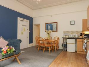 a kitchen and a living room with a table and chairs at Apartment 2 in Torquay