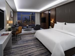 a hotel room with a large bed and a desk at Movenpick Hotel and Residences Riyadh in Riyadh