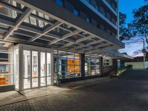 an external view of a building with glass doors at ibis budget Pindamonhangaba in Pindamonhangaba
