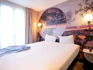 a bedroom with a white bed and a mural at ibis styles Paris Montmartre Batignolles in Paris +45 photos