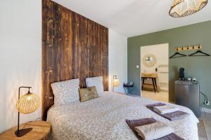 a bedroom with a bed with a large wooden headboard at Le Pech Eternel - La Sablière in Sarlat-la-Canéda