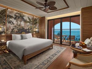 a bedroom with a bed and a living room at Mövenpick Resort Phan Thiet in Phan Thiet