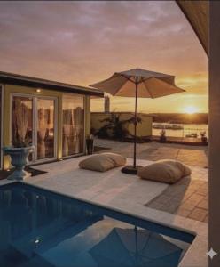 an umbrella sitting next to a swimming pool at Bungalow Lux in Novi Banovci