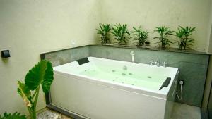a bathroom with a bath tub with potted plants at La Damai in Aldūr +10 photos