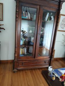 a wooden cabinet with glass doors in a room at Casa Rural in Esposende