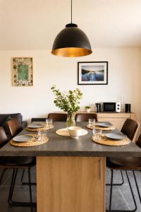 a dining room table with plates and glasses on it at Charmant T2 Bordeaux Proche tram & centre-ville in Bruges