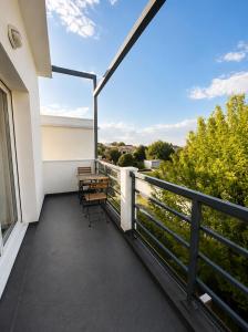 a balcony with a table and chairs on a building at Charmant T2 Bordeaux Proche tram & centre-ville in Bruges