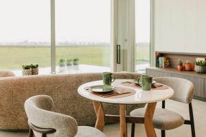 a table and chairs in a living room with a couch at De Droomtoren - uniek overnachten in een watertoren nabij Maastricht in Riemst