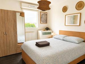 a bedroom with a large bed and a window at Charmant T2 Bordeaux Proche tram & centre-ville in Bruges