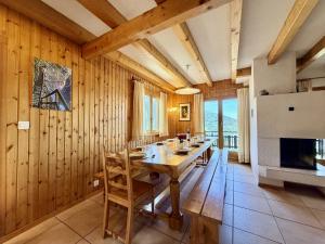 a dining room with a table and a fireplace at Eanta SUNNY & MOUNTAIN chalet 10 pers by Alpvision Résidences in Veysonnaz