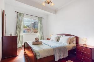 a bedroom with a bed and a large window at Paradise Dream in Caniço