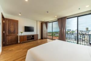 a hotel room with a bed and a television at Dian Hotel & Apartment in Danang