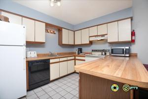a kitchen with white appliances and wooden cabinets at Senedo Springs Duplex #90A in Basye