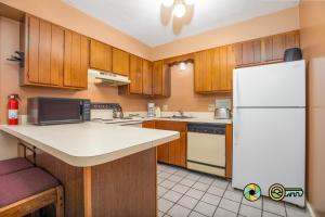 a kitchen with wooden cabinets and a white refrigerator at Senedo Springs Duplex #98A in Basye +24 photos