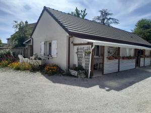 a small white house with a garage with flowers at Studio Clos-Edeen in Tréclun