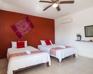 zwei Betten in einem Zimmer mit Deckenventilator in der Unterkunft Balamku Hotel Petit in Campeche