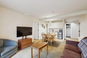 a living room with a couch and a tv and a table at Seasons 207 in Warren +6 photos