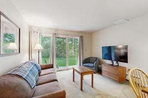 a living room with a couch and a flat screen tv at Seasons 207 in Warren