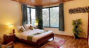 a bedroom with a bed and a large window at Umda Hotel in Nathia Gali
