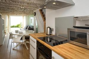 a kitchen with a stove top oven next to a table at 2 Bed in Pwllheli oc-glanab in Abersoch +8 photos