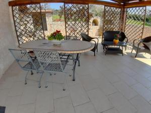 a patio with a table and chairs on a tile floor at B&B La Rosa dei Trulli Alberobello in Alberobello