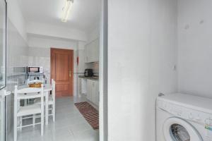a kitchen with a washing machine and a washer at Paradise Dream in Caniço