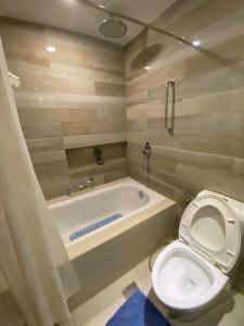 a bathroom with a toilet and a bath tub at R2 condotel tower in Manila +13 photos