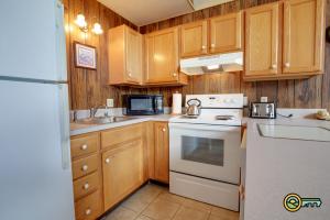 a kitchen with wooden cabinets and a white stove top oven at Villa #162 in Basye +29 photos