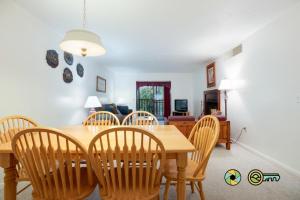 a dining room and living room with a wooden table and chairs at Senedo Springs Condo #2-202 in Basye